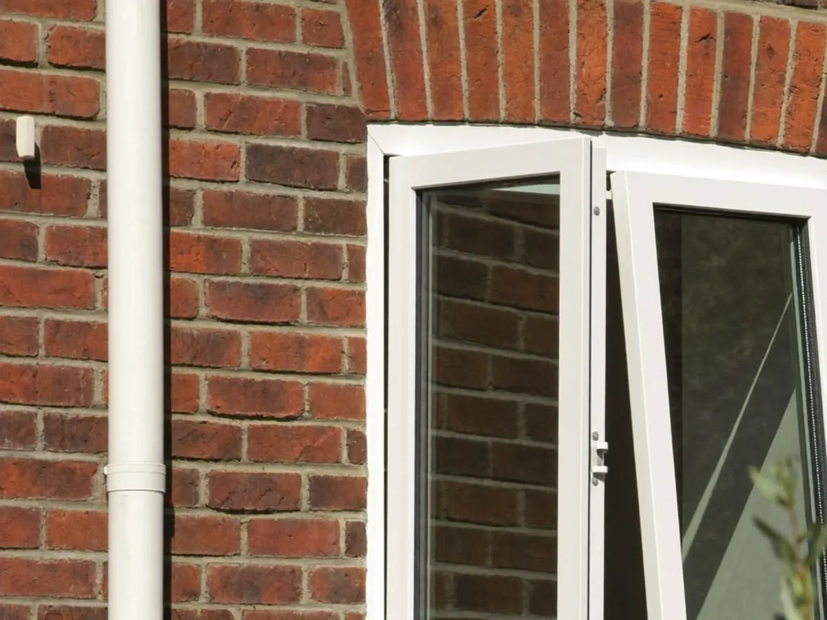 A front bay window on a UK brick house viewed from the pavement