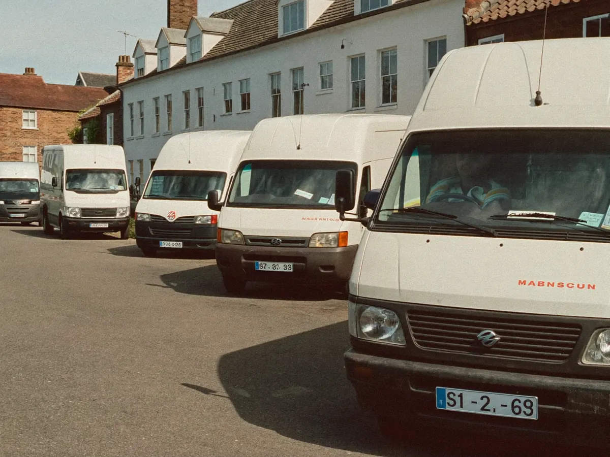 Three tradesperson vans parked along a residential UK street
